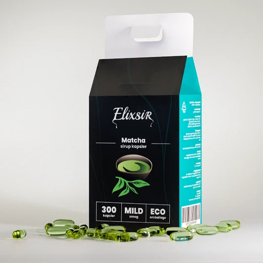 Elixsir Matcha box seen at an angle, surrounded by green capsules, showing the turquoise side and open top.