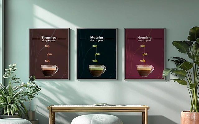 Three framed Elixsir posters hanging on a light green wall, each showcasing a different syrup flavor—Tiramisu, Matcha, and Honey—above a layered coffee drink. Surrounded by plants and a wooden bench in a cozy, modern setting.