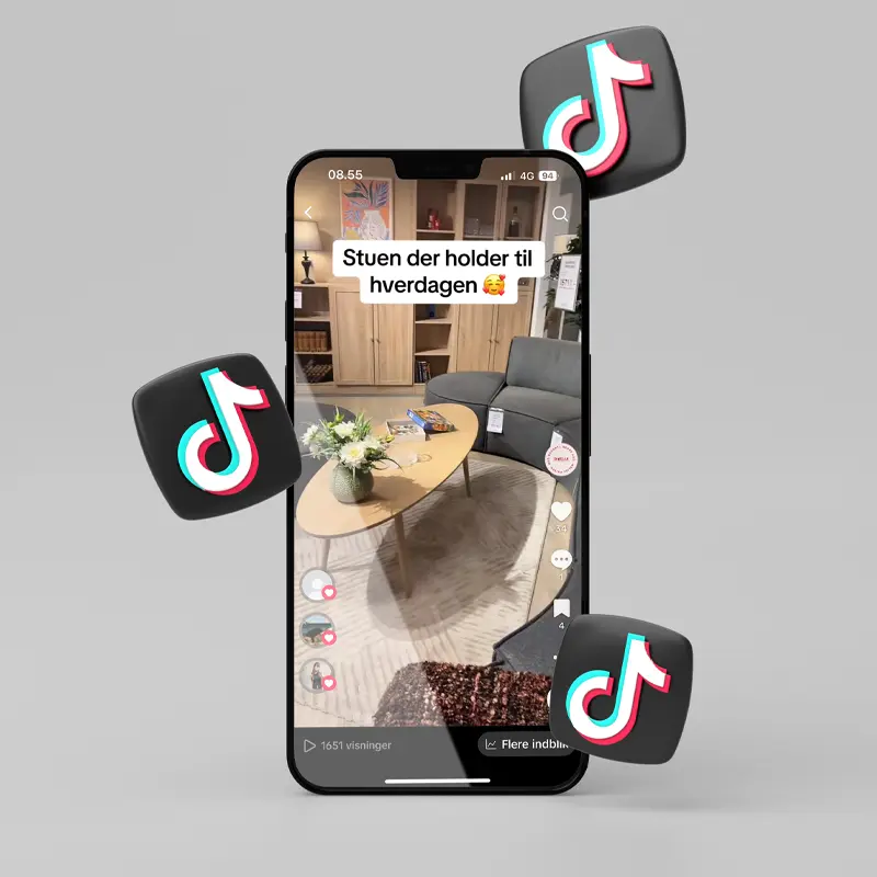TikTok video mockup of a Daells Bolighus living room setup shown on a smartphone screen, with floating TikTok logos on a grey background.